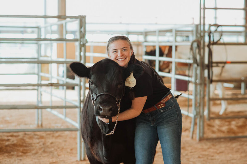 A girl hugging her cow