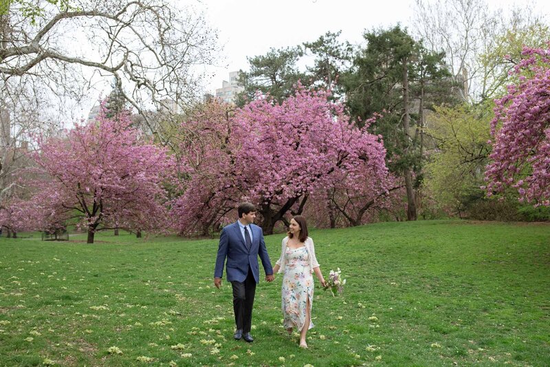 nyc central park spring elopement couple with cherry blossoms and floral dress