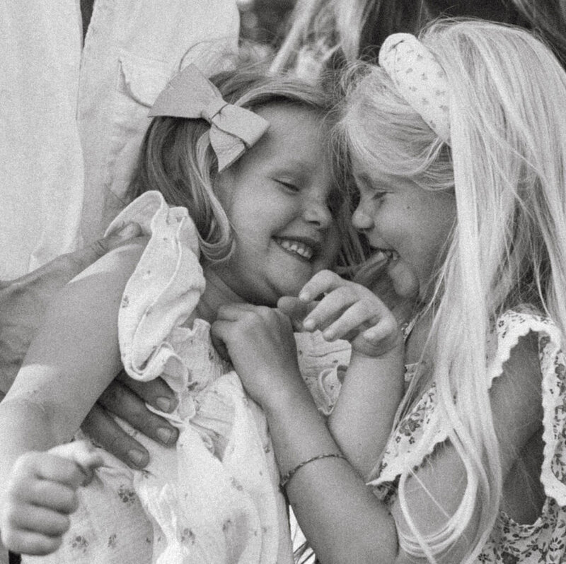 Two sisters giggling and enjoying a fun moment during a family photo session in Oregon