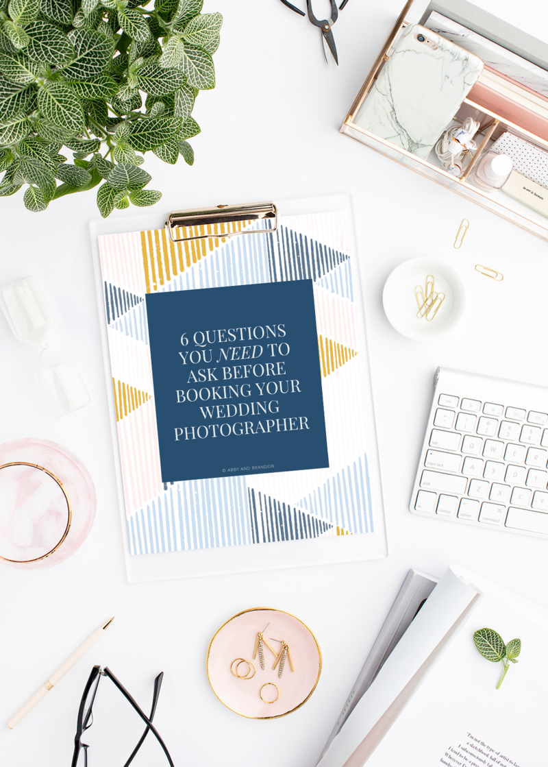 A desktop image with a clipboard. The paper reads "6 questions you need to ask before booking your wedding photographer"