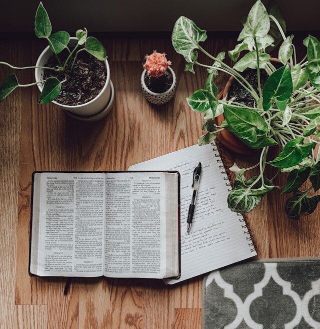 Image of open Bibles, notebook and pen
