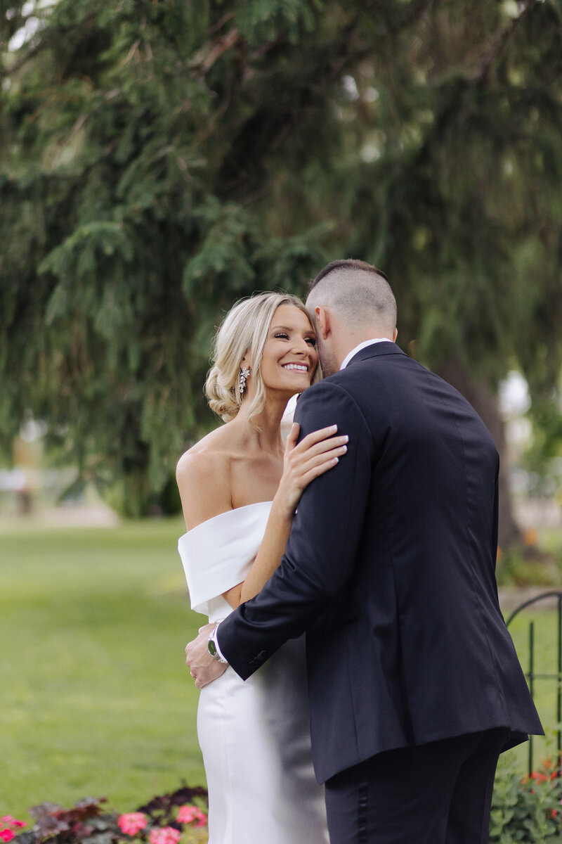 Bride smiling while being held by groom