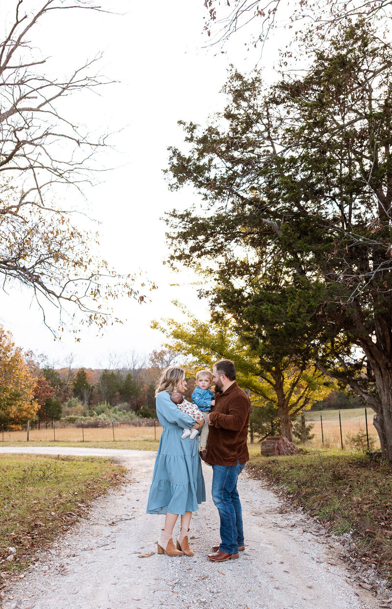 Family portrait taken in driveway of father, mother, toddler and newborn taken in De Soto, Missouri. 