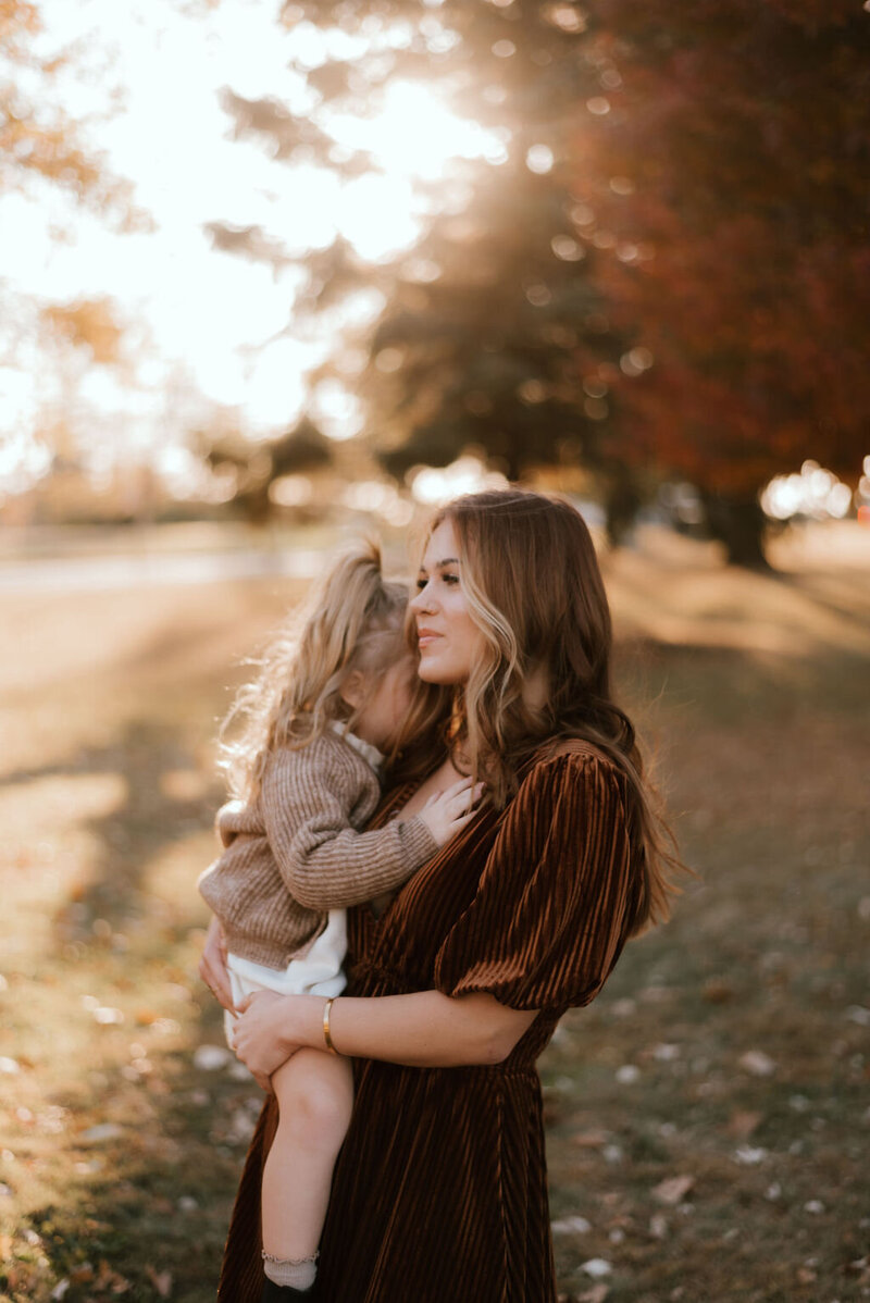mom holds daughter for family portraits in peoria il