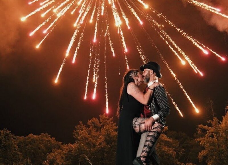 A newlywed couple kissing as fireworks go off 