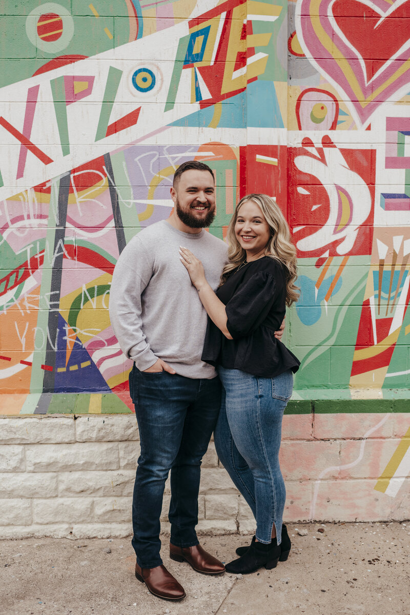 couple posing by colorful mural in savannah engagement session