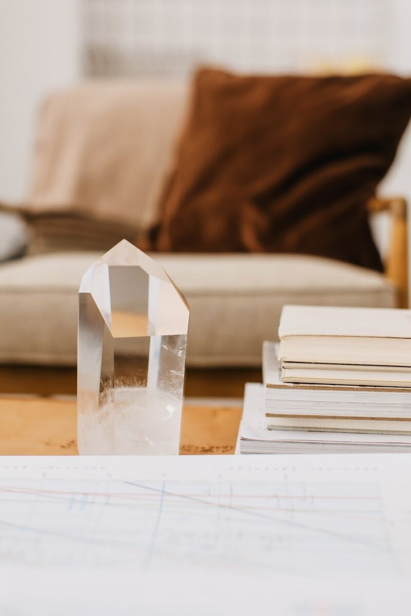 crystal and books on a coffee table with an astrocartography map