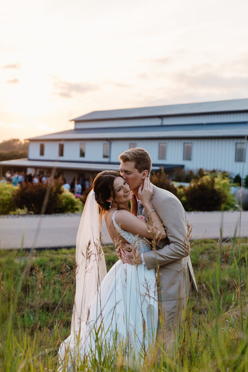 A person kissing their new spouse's cheek as they smile