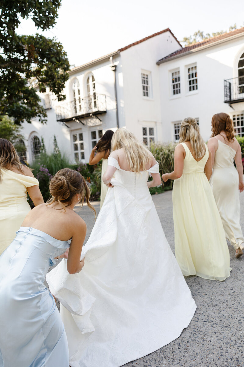 Bride and Bridesmaids walking towards the venue in Arkansas summer wedding.