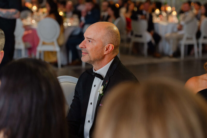 Ottawa wedding photos of the father of the bride smiling fondly at his daughter as she says her speech during her Chateau Le Parc reception.
