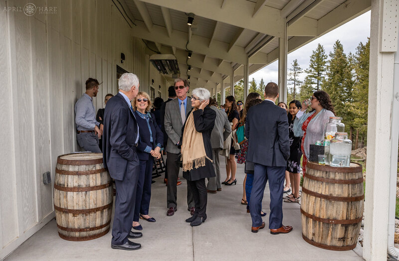 Guests Mingle on the Outdoor covered patio at The Woodlands Barn Wedding Venue in Colorado