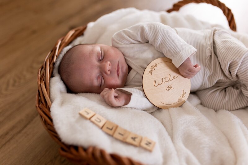 Baby Julian liegt gemuetlich in einem Korb auf einer Decke