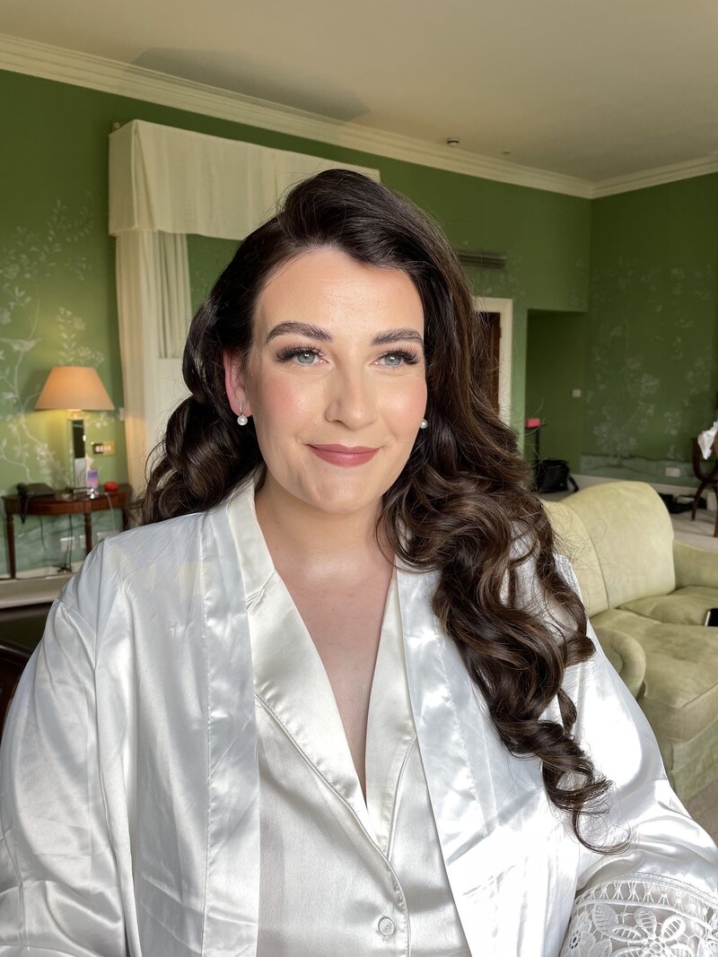 A radiant bridal makeup look created by Abby Kaye, featuring glowy skin, neutral eyeshadow, and a soft pink lip.