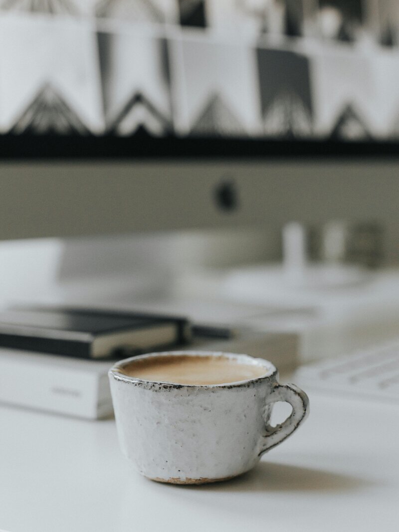 Workspace with coffee mug and open laptop, ready for client support and business tasks