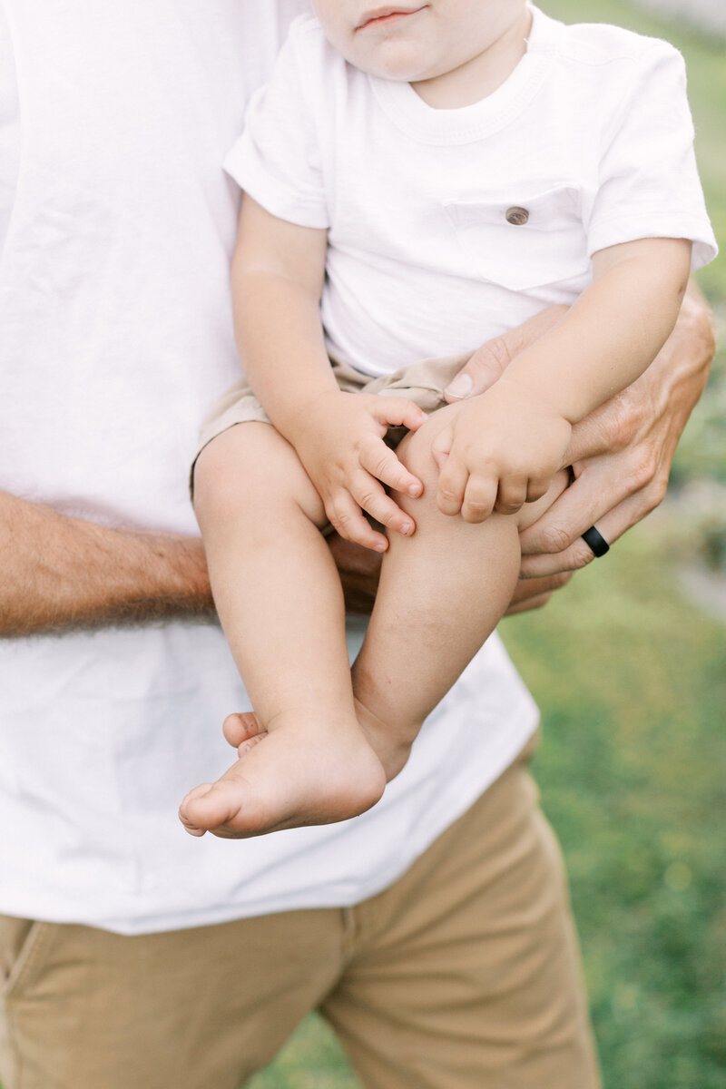 Details of a dad's hands holding his son