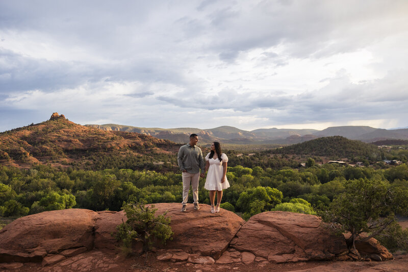 couple standing on red rocks
