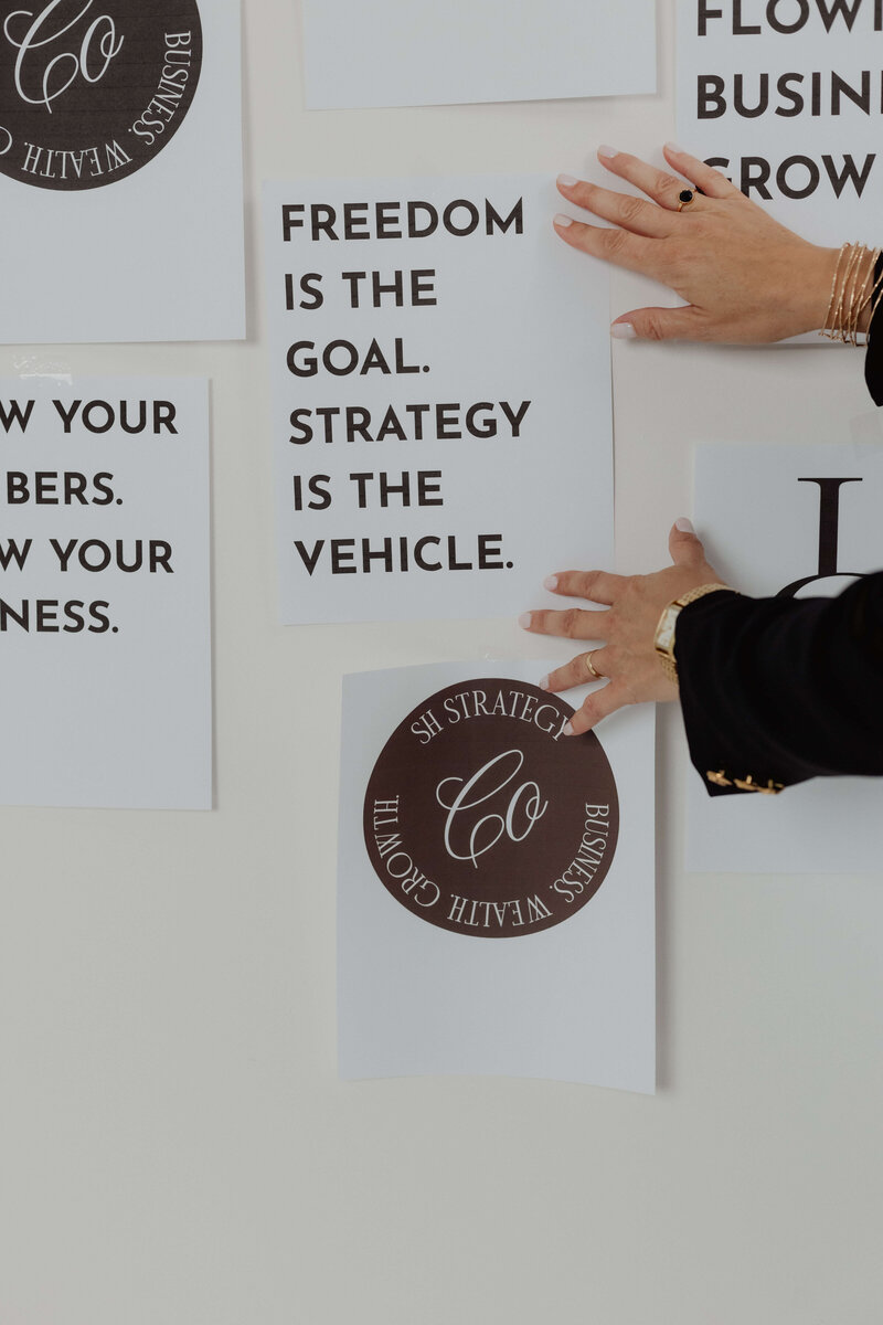A women holding papers attached to the wall about financial strategy.
