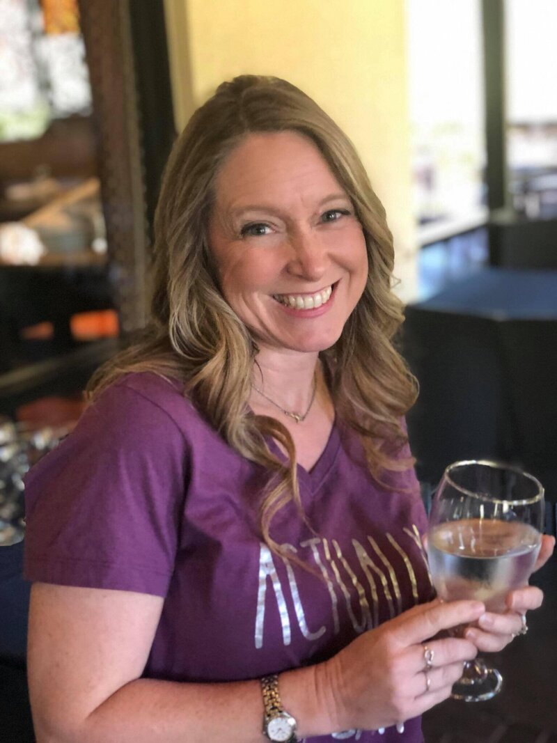 Terra, founder of Adventures by Terra, holding wine glass.