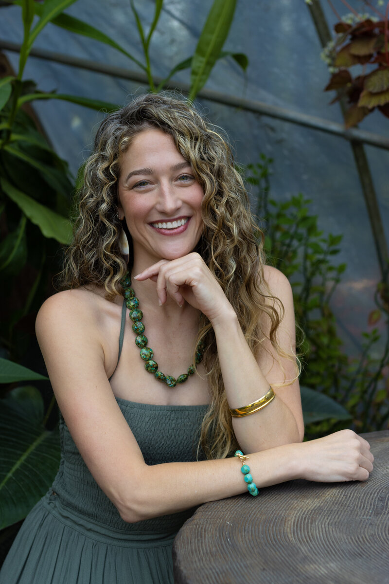 Dr. Mamie Burruss, ND, LAc, smiling in a greenhouse