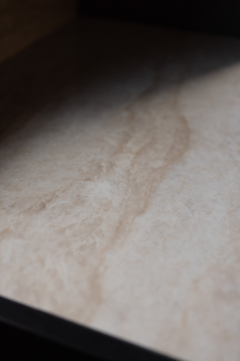 Een close-up van het marmeren blad waarin je de natuurlijke textuur en unieke tekening van het materiaal goed ziet.