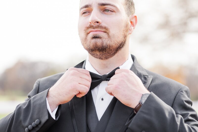 Groom adjusting his bow tie at his River Place Wedding