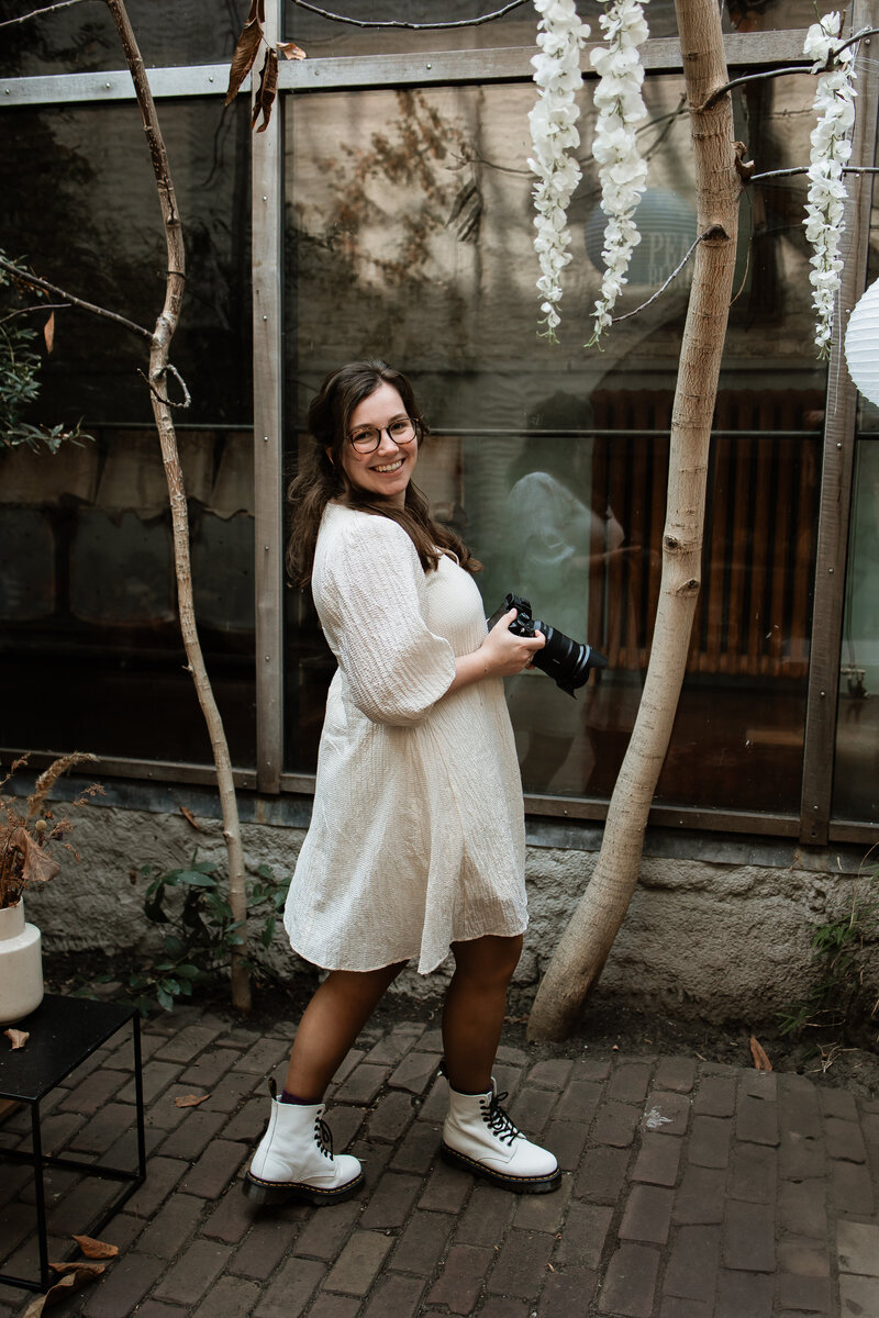 Portret Anna Hage met camera in duinen