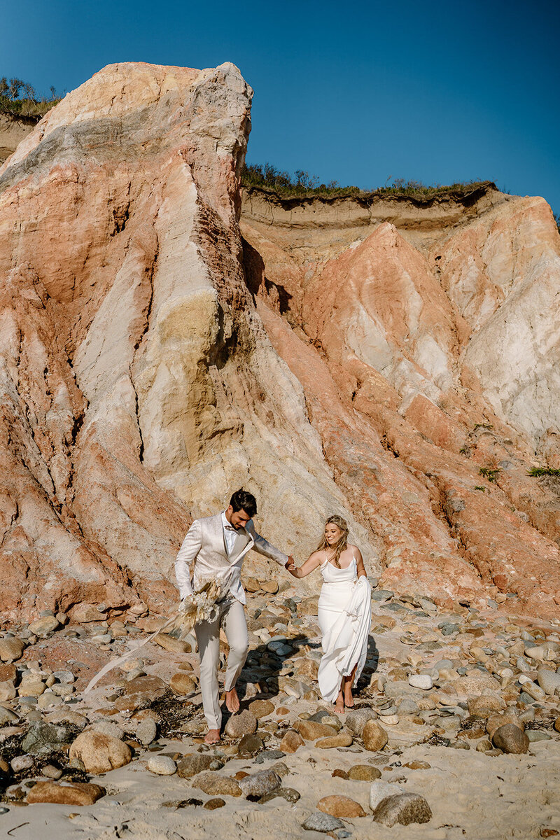 wedding couple walking by aquinnah cliffs