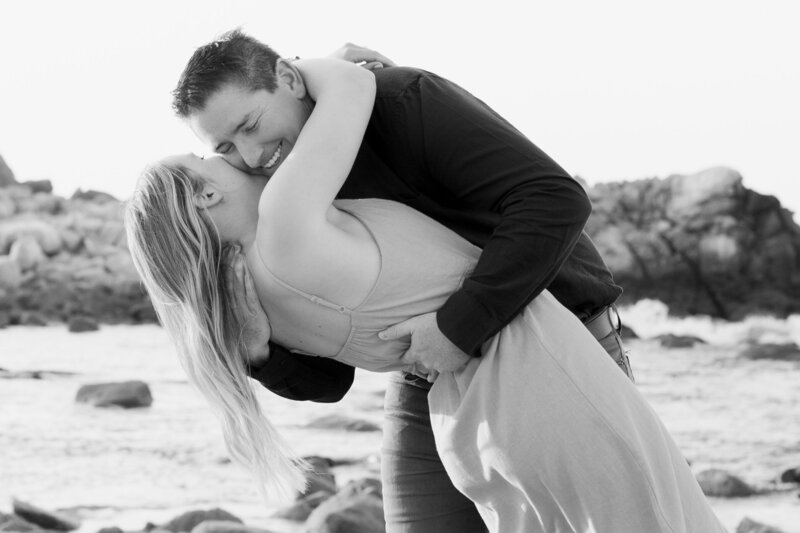 Couple embracing at Pacific Grove beach for engagement photographs