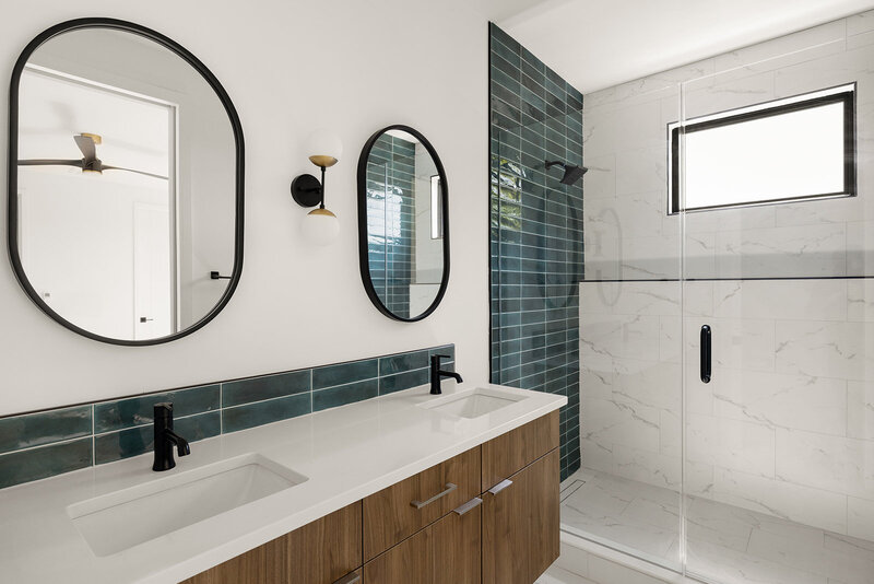 ensuite bathroom with green tile in walk in shower with matte black accents