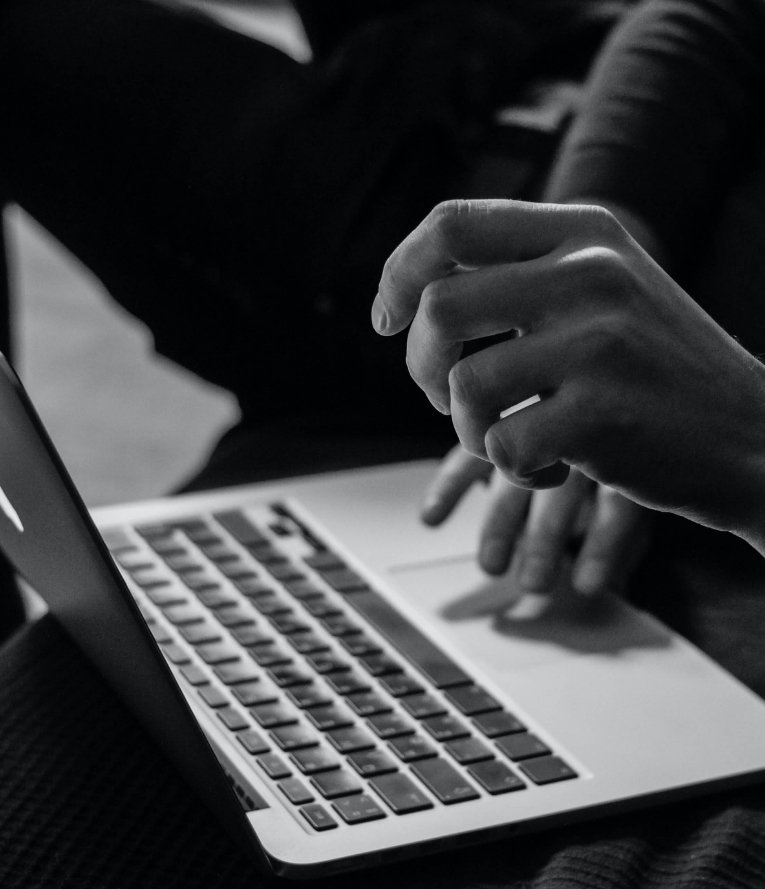 black and white photo of person sitting on laptop