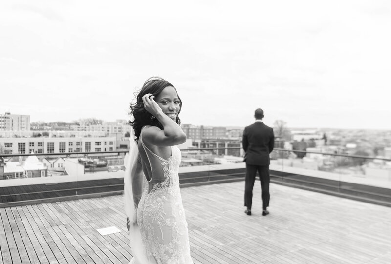 black and white photo of bride going to first look on rooftop