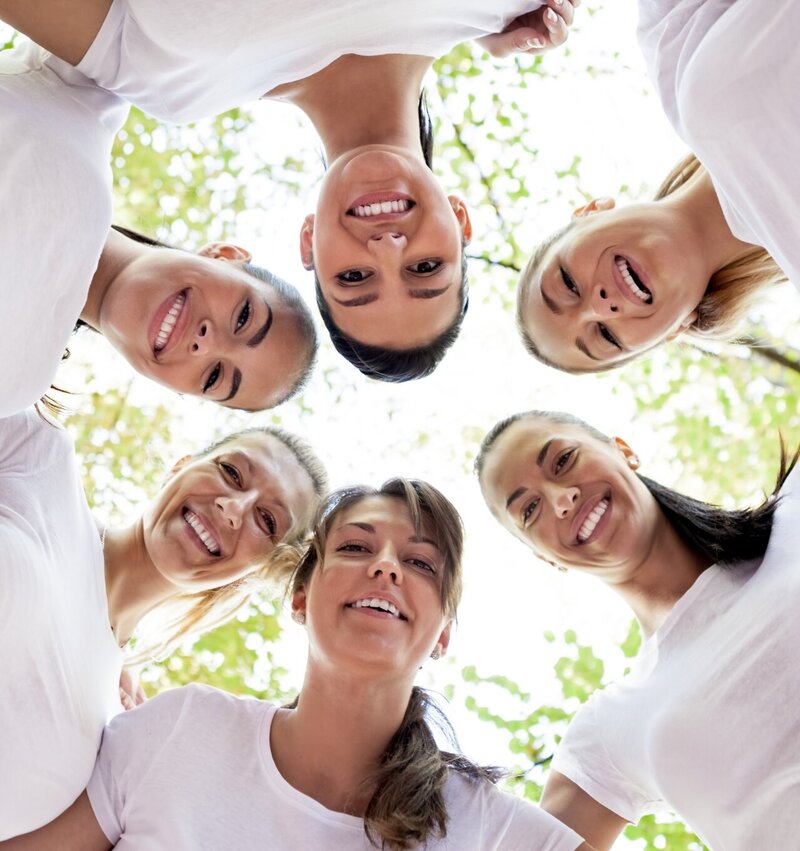 Group of smiling midlife women standing in a supportive circle, symbolising the empowering community inside Menopause.Rescripted.