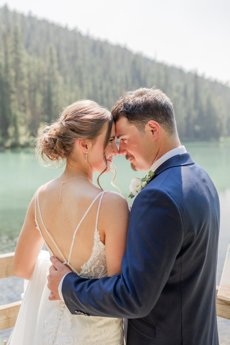 Couple with their arms around each other laughing and walking on a beach