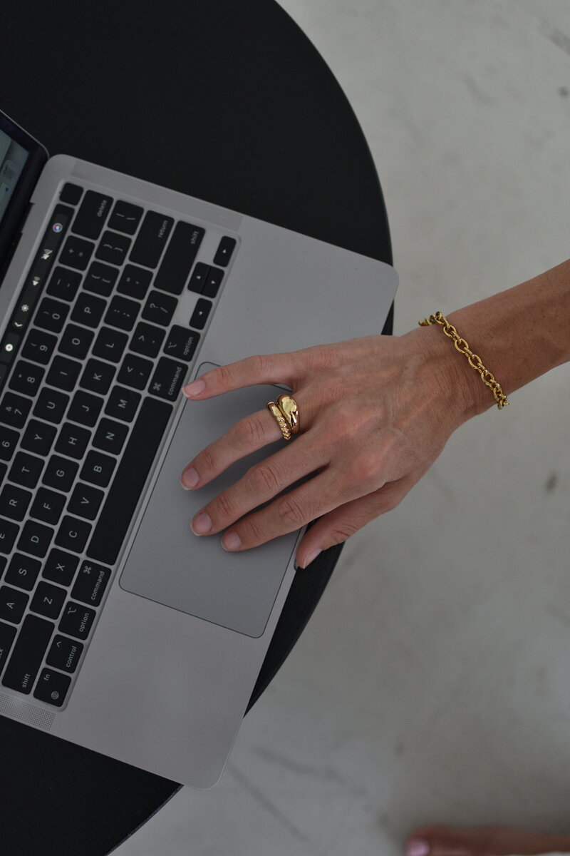 Woman using apple laptop on small black desk