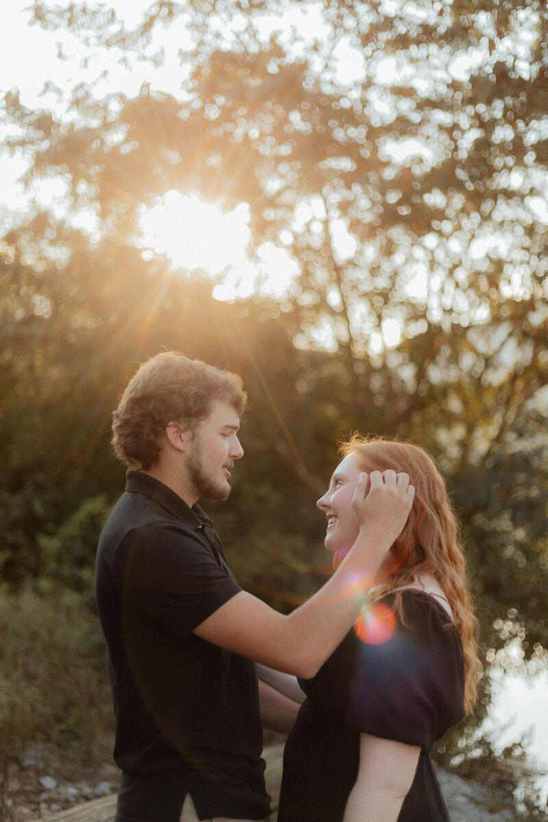 man pushing hair behind woman's ear