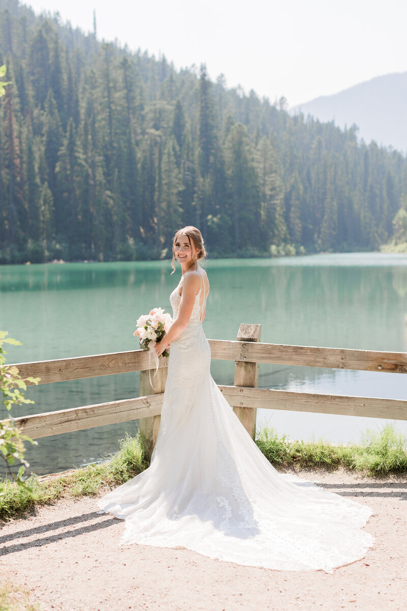 Couple with their arms around each other laughing and walking on a beach