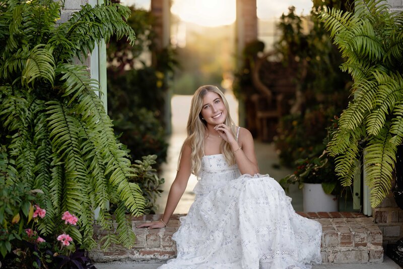 Girl sitting on steps of greenhouse taking Senior photos. Senior Photo taken in Atlanta, GA