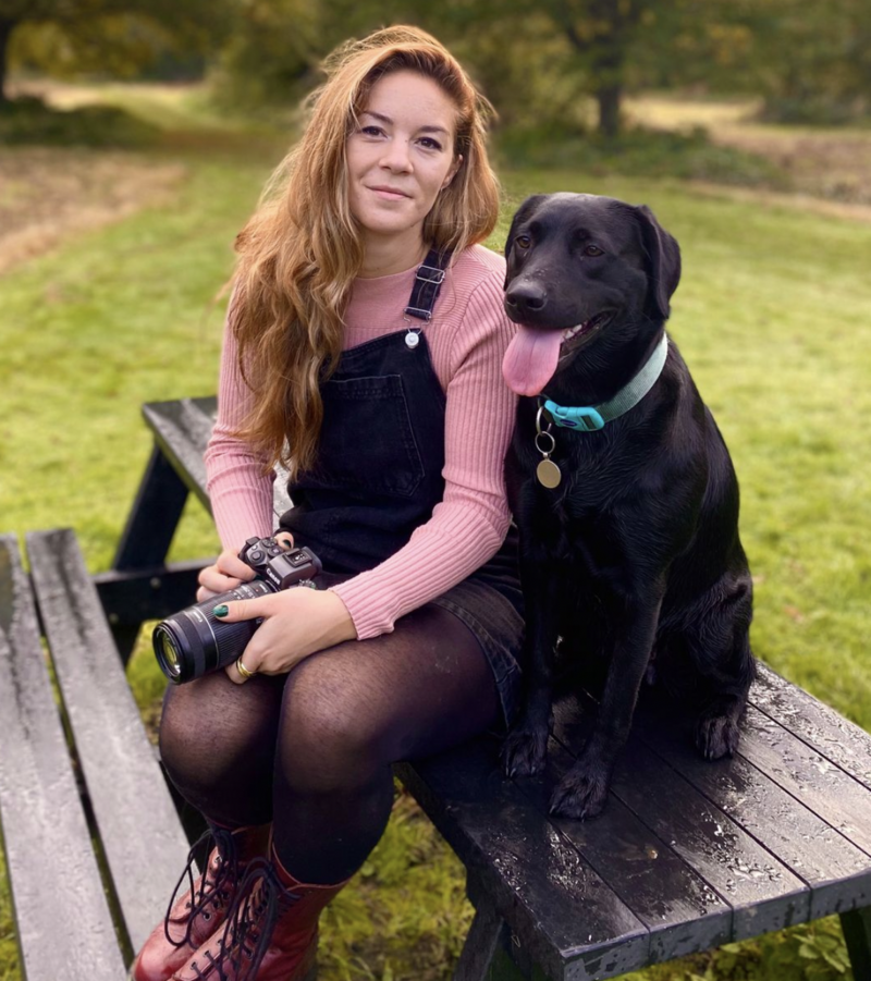 Family Photographer sat on  bench with her camera and her dog