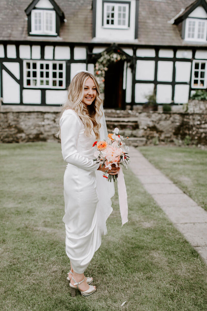 BRIDE CARRYING FLOWERS MARQUEE WEDDING