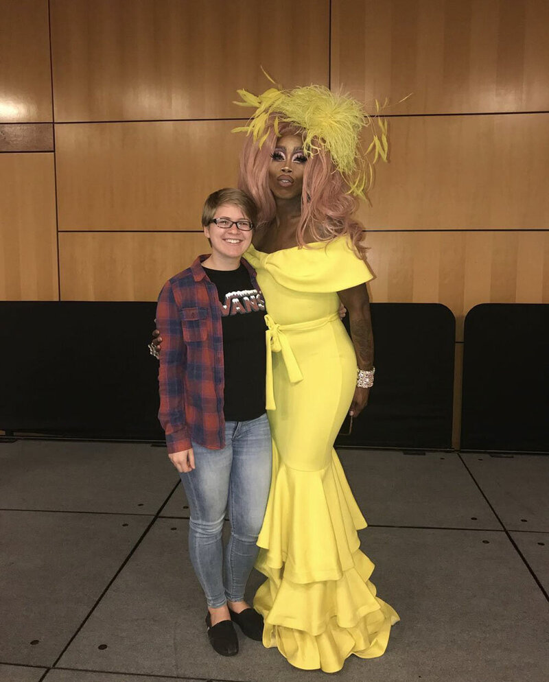 A Virginia wedding photographer stands next to Mo Heart, a drag queen from RuPaul's Drag Race on a stage for a  photo op after a Drag Queen Bingo event at her alma mater.