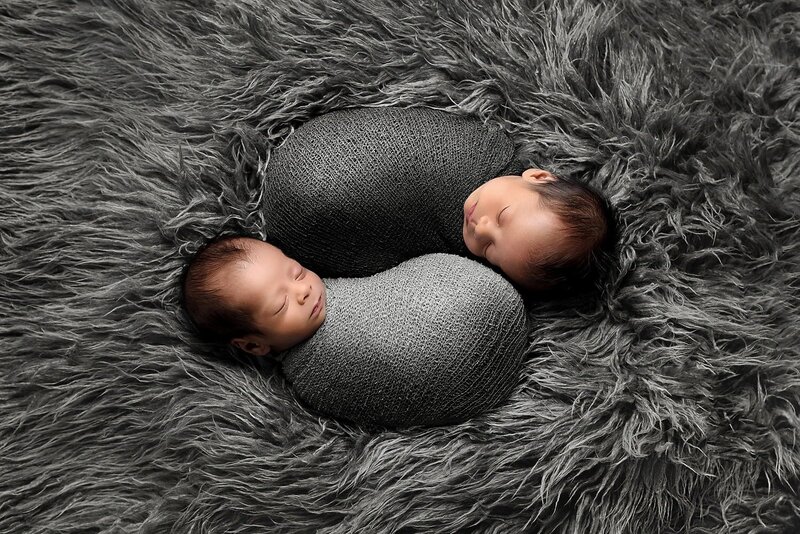 Newborn twin boys wrapped in grey yin-yang themed during an in-home newborn photo session in Surrey.