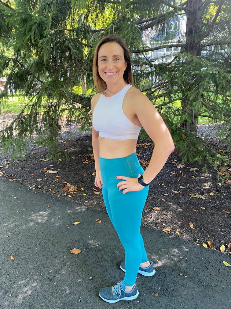 Strength coach Vanessa performing a kettlebell Turkish get-up in a home setting, showcasing real-life midlife strength training