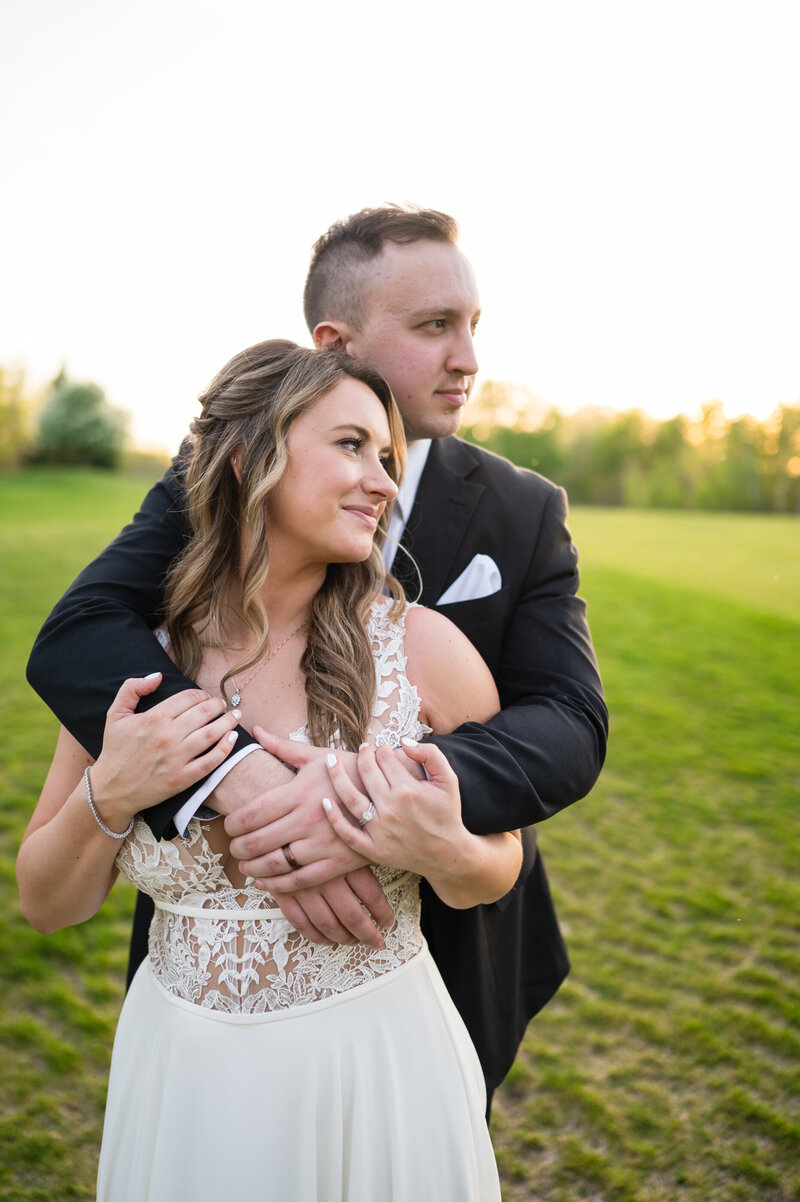 Groom carries his boho bride through a field