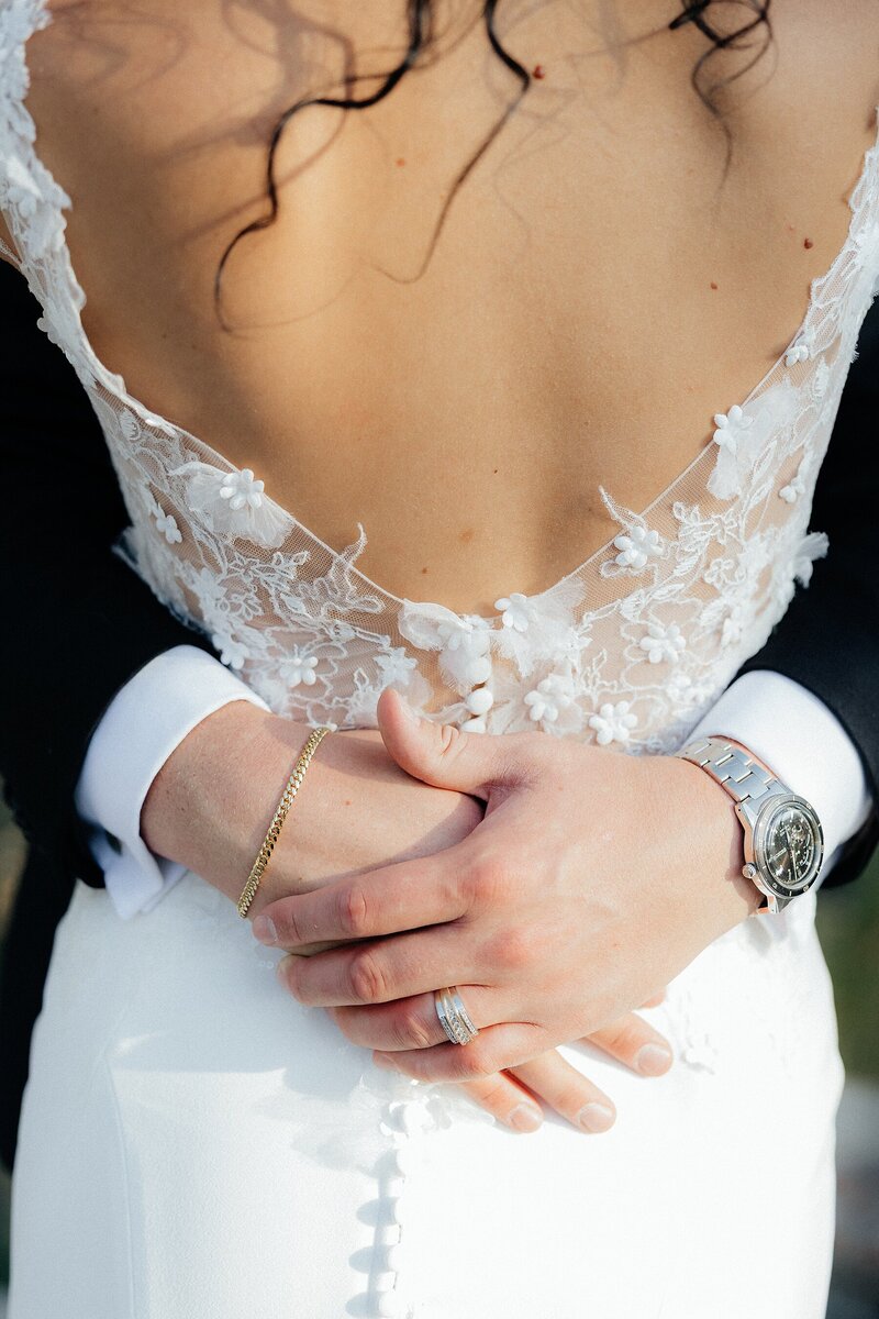 Terrel wrapping his arms around Luisa's waist and showing off his wedding ring.