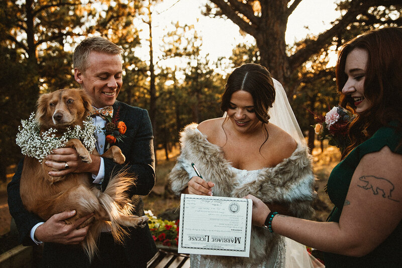 bride and groom and their dog sign marriage license in Colorado