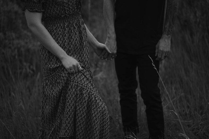 Couple holds hands in the hills of Idaho in black and white.