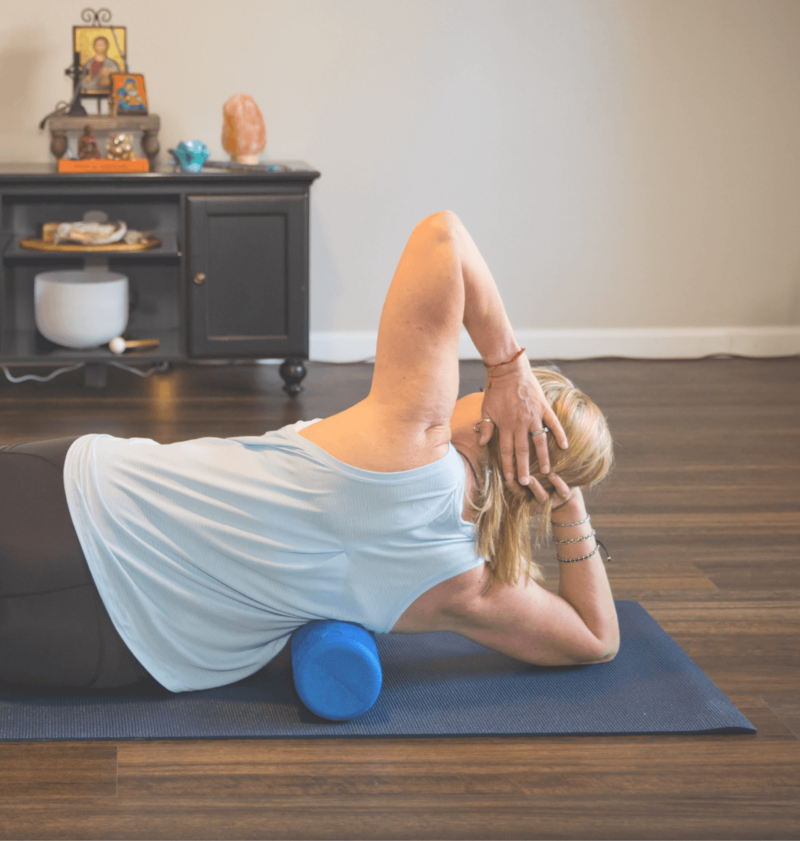 Woman doing a yoga pose on a mat and with a prop