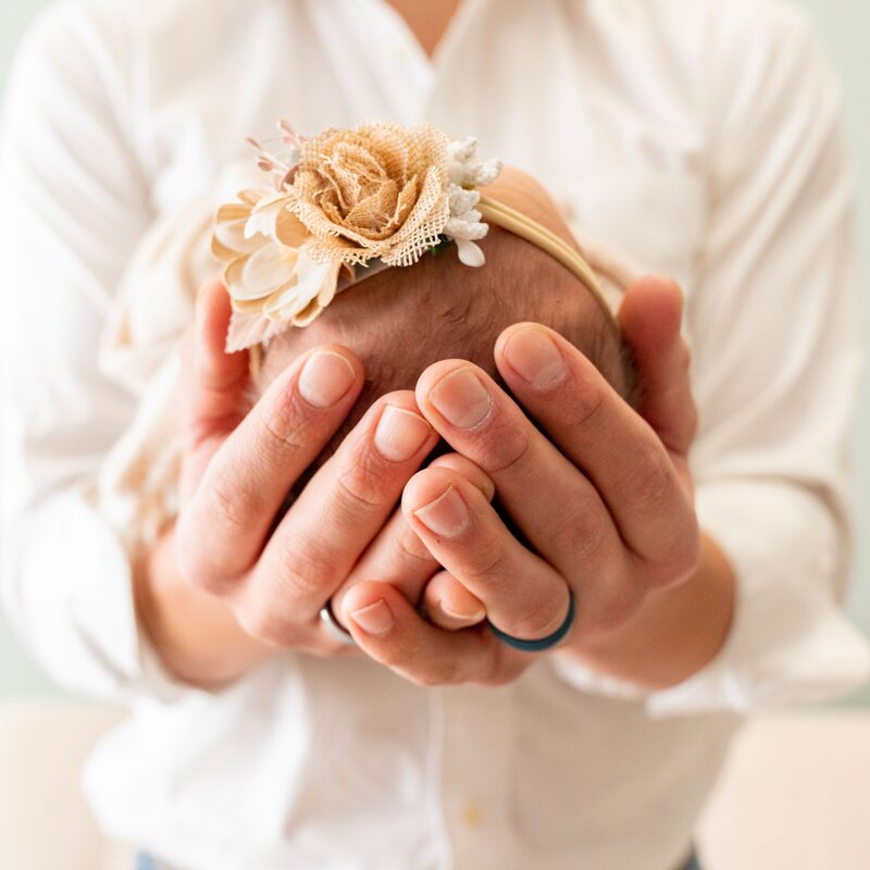 man holding baby's head