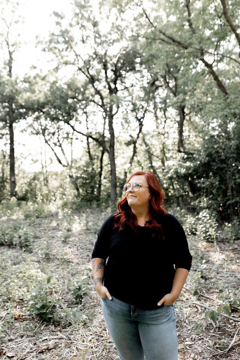 Jess Standing in a tree clearing 