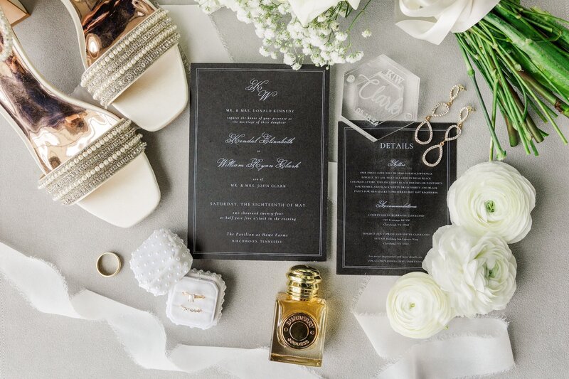 a flat lay with black wedding invitations